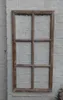 A wooden window frame with six panes is mounted on a white brick wall. Produktbild-Vorschau