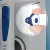 A close-up of a person's fingers adjusting a dial on a white and blue Oral-B product. Náhled obrázku produktu