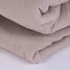 A close-up view of folded beige fabric, likely bedding. Náhled obrázku produktu