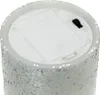 Close-up view of the bottom of a glittery LED candle, showing the battery compartment and switch. Produktbild-Vorschau