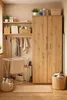 A laundry room or utility space with a large wooden cabinet, shelves, and various cleaning supplies and laundry items. Anteprima dell’immagine prodotto