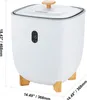A white towel warmer bucket with wooden legs and a wooden handle on the lid, with a digital display on the front. Náhled obrázku produktu