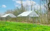 A large outdoor enclosure for pets, such as chickens, set up on a grassy lawn with trees in the background. Voir les images du produit