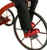 Close-up of a doll's feet on a tricycle pedal. Produktbild-Vorschau