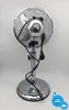 The back view of a silver stand fan on a white background. Produktbild-Vorschau