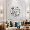 A living room scene featuring a large wall clock above a sofa with decorative pillows and vases. Anteprima dell’immagine prodotto
