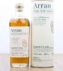 A bottle of Arran Single Malt Scotch Whisky and its cylindrical packaging are displayed on a wooden surface. Produktbild-Vorschau