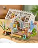 A miniature greenhouse model with plants and gardening tools. Podgląd zdjęcia produktu