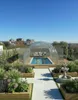 A rooftop garden with a covered swimming pool and people enjoying it. Produktbild-Vorschau