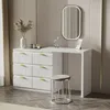 A white vanity table with a mirror and a stool in a room with a textured wall. Produktbild-Vorschau