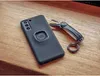 A black phone case with a Quad Lock mount and a key organizer are placed on a wooden surface. Produktbild-Vorschau