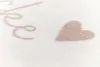 A close-up view of a textured white blanket with a beige embroidered heart and a cursive letter. Produktbild-Vorschau