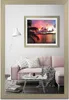A living room scene with a pink sofa, a coffee table, and a framed picture of a sunset hanging on the wall. Produktbild-Vorschau