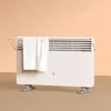 A white Xiaomi electric heater with a towel rack and a white towel draped over it, placed on a light brown floor against a peach-colored wall. Produktbild-Vorschau