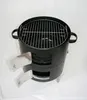 A black charcoal smoker grill with a silver grate and two silver doors on the front, set against a white background. Produktbild-Vorschau
