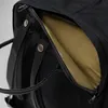 A close-up view of a black backpack with a partially opened zippered compartment revealing a gold-colored interior. Anteprima dell’immagine prodotto