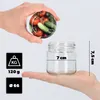 A hand holds a jar lid filled with tomatoes and cucumbers above an empty glass jar held in another hand. Dimensions and weight are indicated with text and icons. Produktbild-Vorschau