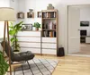 A cozy living room scene featuring a bookshelf and dresser. Produktbild-Vorschau