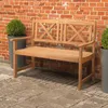 A wooden park bench sits on a brick patio in front of a brick wall, with potted plants on either side. Voir les images du produit