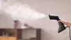 A hand holding a black garment steamer emitting steam. Náhľad obrázku produktu