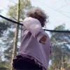 A child is jumping on a trampoline outdoors. Podgląd zdjęcia produktu