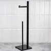 A black toilet paper stand is shown against a white tiled wall and a gray floor. Voir les images du produit