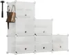 A white modular shoe storage unit with a brown handbag and a black umbrella hanging from it, along with a black mallet. The unit is arranged in a stepped pyramid shape. Produktbild-Vorschau