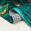 A close-up view of a rug, showing the texture and pattern. The rug is partially rolled, revealing its underside with a patterned grip. Náhled obrázku produktu