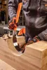 A person wearing work gloves is using a curved saw to carve a groove into a wooden beam. Produktbild-Vorschau