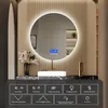 A modern bathroom vanity with a round LED mirror, sink, and faucet, featuring a digital display on the mirror and control icons below. Náhled obrázku produktu