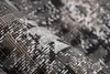 A close-up, rolled-up view of a rug with a detailed pattern. Produktbild-Vorschau