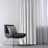 A chair with a pillow next to a white curtain. Produktbild-Vorschau