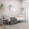 A white metal daybed is set up in a room with a plant, side table, and decorative mirrors on the wall. Podgląd zdjęcia produktu