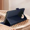 A dark blue phone case is displayed on a table with a woven placemat. Produktbild-Vorschau