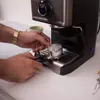 A person is preparing an espresso machine. Produktbild-Vorschau