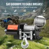 A winch is shown in a grassy, mountainous outdoor setting with an ATV in the background. Voir les images du produit