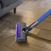 A vacuum cleaner head with a soft roller brush is shown cleaning a wooden floor next to a sofa. Produktbild-Vorschau