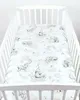 A baby crib with a fitted sheet featuring a pattern of elephants and clouds. Produktbild-Vorschau