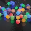 A pile of colorful LED party lights on a dark surface. Produktbild-Vorschau