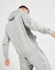 A person wearing a grey tracksuit, viewed from the back. Produktbild-Vorschau