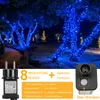 Trees decorated with blue string lights at night, with a power adapter and control box shown in the foreground. Produktbild-Vorschau