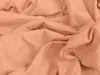 A close-up view of crumpled peach-colored fabric. Produktbild-Vorschau