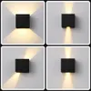 A collage of four images showing a black square wall light fixture mounted on a white wall, with light emanating upwards and downwards. Náhľad obrázku produktu