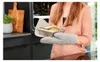 A person is taking a food container out of an oven in a kitchen. Produktbild-Vorschau
