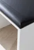 A close-up view of the corner of a white vanity table with a black upholstered seat. Produktbild-Vorschau