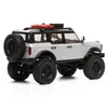 A remote-controlled toy car, a white Ford Bronco, is shown from a rear-side angle against a white background. It has a spare tire mounted on the back and red accessories on the roof rack. Podgląd zdjęcia produktu