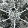 Close-up view of the flocked branches and central connector of an artificial Christmas tree. Náhled obrázku produktu