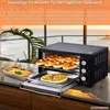 A mini oven is shown on a kitchen counter with food inside and next to it, with a scenic view of the ocean and plants in the background. Podgląd zdjęcia produktu