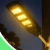 A solar street light mounted on a pole attached to a wall, illuminating the dark. Anteprima dell’immagine prodotto