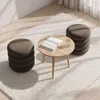 A round coffee table with a book and a glass of water, surrounded by stacked round cushions on a fluffy rug. Produktbild-Vorschau